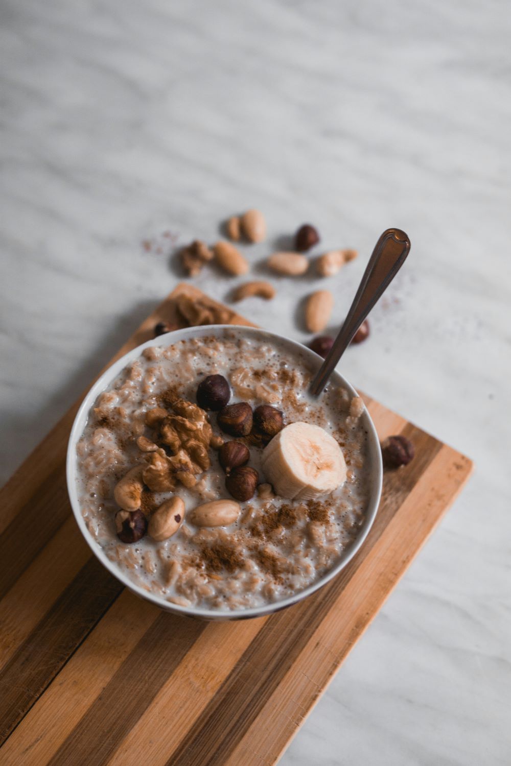 bowl of oatmeal with hazelnuts and banana