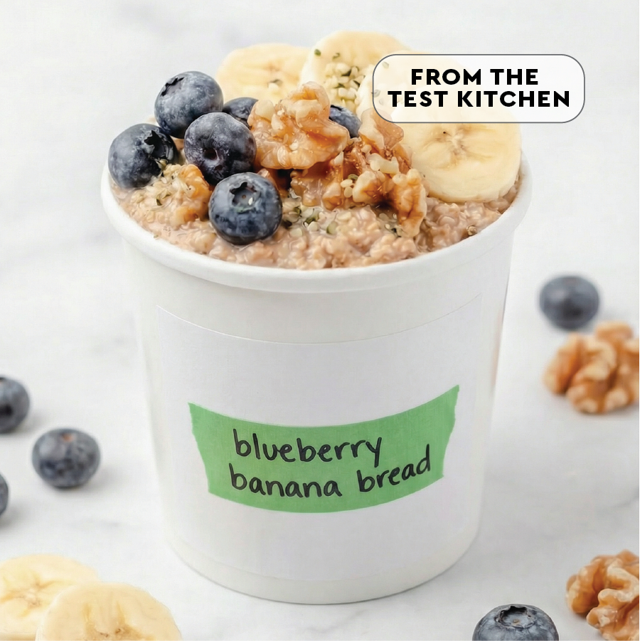Container of blueberry banana bread flavored oatmeal with blueberries and banana slices on top, labeled 'From the Test Kitchen'.