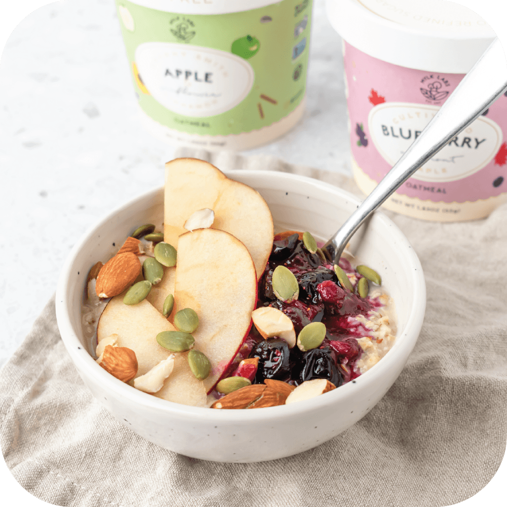 A bowl of oatmeal with fruit and nuts.