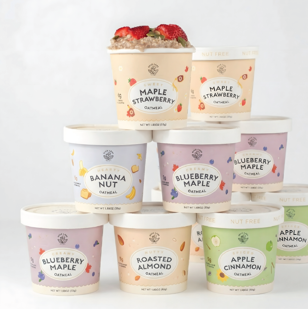 Stack of oatmeal containers with various flavors on a white background