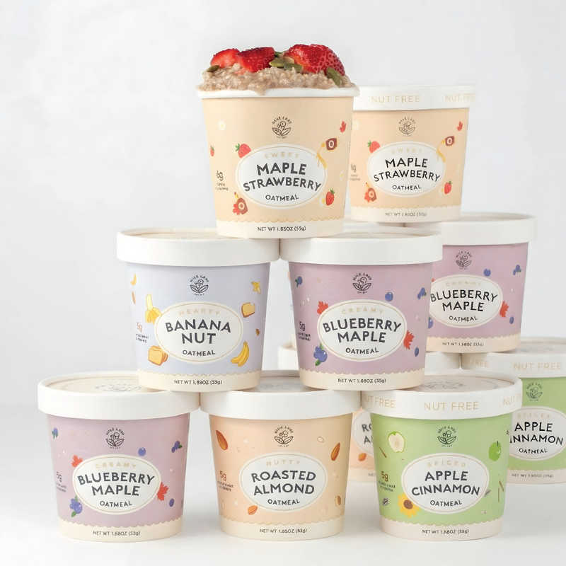 Stack of oatmeal containers with various flavors on a white background