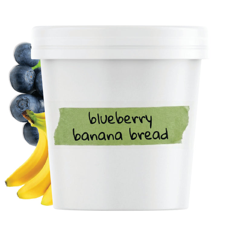 Container of blueberry banana bread with blueberries and bananas on a white background